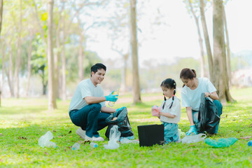 Asian family on summer vacation, parents teaching children to pick up plastic bottles and trash in...