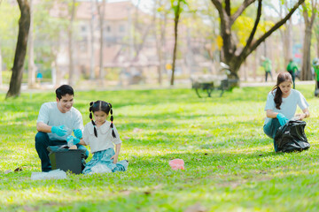 Asian family on summer vacation, parents teaching children to pick up plastic bottles and trash in...