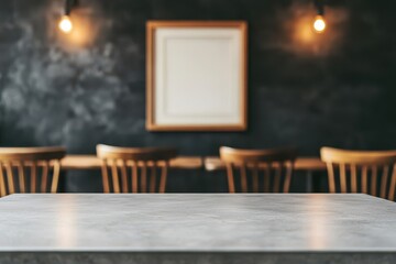 Empty marble table with wooden chairs and a blank framed picture on a dark textured wall, lit by two warm hanging light bulbs in a cozy room.