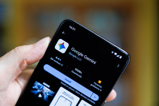 Phone in hand displaying Google Gemini app on Google Play Store