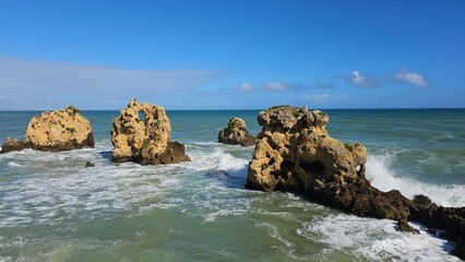 Panoramic scenic view of the ocean, caves, large rocks under the blue sky in Albufeira Portugal