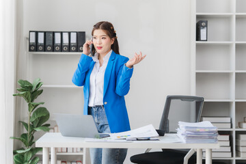 Young asian beautiful and charming busineswoman smiling and working on laptop computer at office.