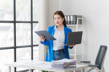 Young asian beautiful and charming busineswoman smiling and working on laptop computer at office.