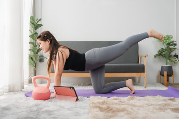 Woman's fitness at home: A woman focused and energetic performing at-home exercise, embracing a...