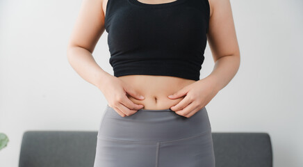 Body Shape Assessment: A close-up perspective showing a person pinching skin around belly,...
