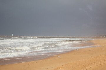 Stormy beach .Ocean Shoreline with Receding Wave and Distant Pier