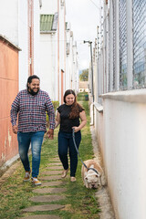 Fresh air and fun: couple walking bulldog in park. A joyful couple shares a sunny park moment with...