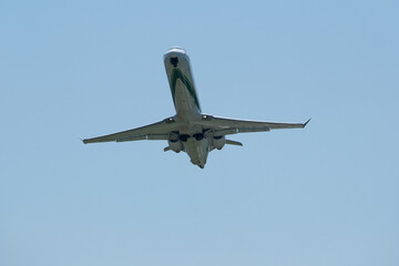 Airplane Takeoff and Climb Against Clear Blue Sky. Dynamic view of a jet aircraft ascending after takeoff.  Airplane taking off against blue sky