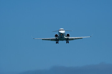 Airplane Landing Approach Against Clear Blue Sky. Airplane in the blue sky, close-up of the plane