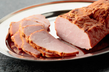 Delicious smoked ham on a metal tray.