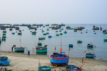 Colorful Basket Boats and Fishing Trawlers Anchored Off the Coast of Mui Ne, Vietnam