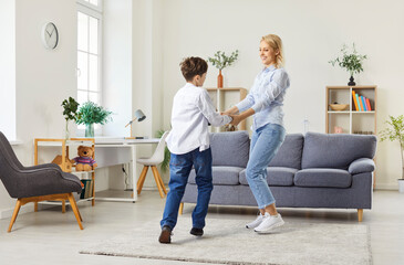 Family moment with a mother and son dancing and playing together at home. They are enjoying leisure time filled with fun and happiness, highlighting close bond and joyful interaction.