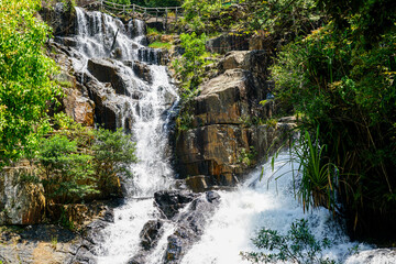 Rushing Datanla Waterfall Cascading Over Rocky Cliffs in the Lush Green Forest of Da Lat, Vietnam