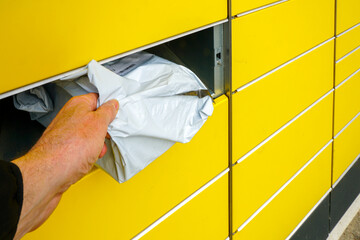 Man Retrieves Parcel from Yellow Automated Locker Using a Self-Service Pickup System