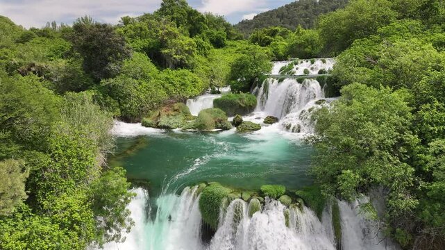 Panoramic aerial view of Krka waterfalls and surrounding forest. The video captures the full width of the cascading water and the natural parkland.