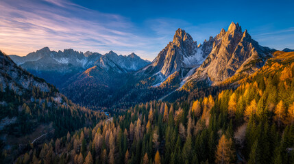 Obraz premium Majestic mountain range overlooking a colorful autumn forest at sunset