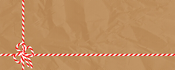 A festive background with a kraft paper texture and a red and white candy cane ribbon. Perfect for Christmas gifts, holiday packaging and winter designs