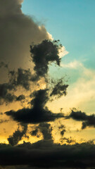 Ragged clouds in silhouette at golden hour in Florida, drifting so as to suggest the form of someone in a skirt walking across the evening sky. Motifs of perception, connections, anthropomorphism.