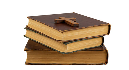 A stack of old leather bound books with a small wooden christian cross placed on top isolated on white background