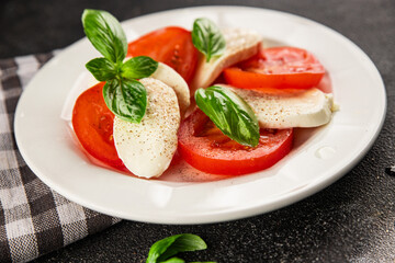 Caprese salad mozzarella and tomato, basil fresh delicious gourmet food background on the table rustic food top view copy space keto and paleo diet vegan and vegan food