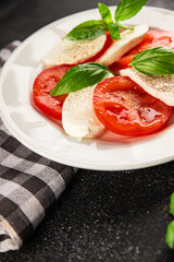 Caprese salad mozzarella and tomato, basil fresh delicious gourmet food background on the table rustic food top view copy space keto and paleo diet vegan and vegan food