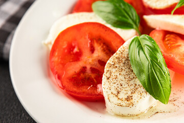 Caprese salad mozzarella and tomato, basil fresh delicious gourmet food background on the table...
