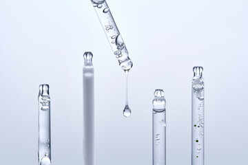 Five different droppers with facial serum in a row.