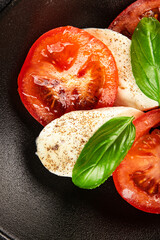Caprese salad mozzarella and tomato, basil fresh delicious gourmet food background on the table rustic food top view copy space keto and paleo diet vegan and vegan food