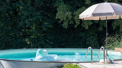 A swimming pool in a garden near a forest, summer holidays