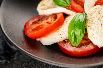 Caprese salad mozzarella and tomato, basil fresh delicious gourmet food background on the table rustic food top view copy space keto and paleo diet vegan and vegan food