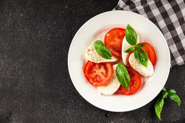 Caprese salad mozzarella and tomato, basil fresh delicious gourmet food background on the table rustic food top view copy space keto and paleo diet vegan and vegan food