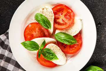 Caprese salad mozzarella and tomato, basil fresh delicious gourmet food background on the table rustic food top view copy space keto and paleo diet vegan and vegan food