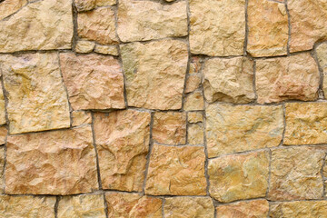 A wall's texture composed of irregular stone blocks of varying sizes and shades. This robust surface is ideal for backgrounds, construction, and design projects.