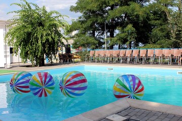 swimming pool for recreation. outdoor pool with blue water and floating balls for recreation and...