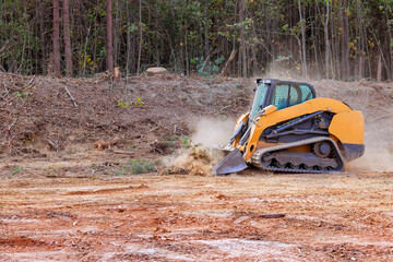 Excavator removes trees, clears land in rural setting, preparing area for upcoming construction...