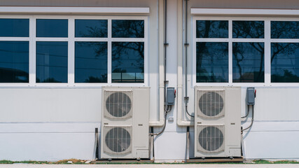 Air conditioner compressor installed on the wall of a building.