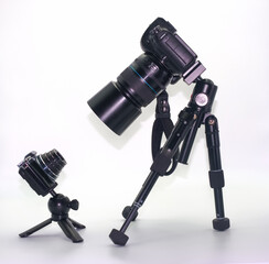 Camera equipment setup features a large DSLR camera and a compact digital camera in a studio environment