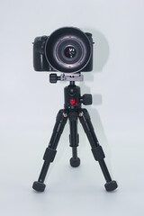 Camera on tripod ready for photography session in studio setting with neutral background