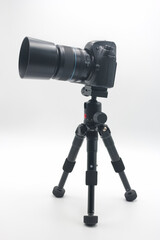 Perfectly positioned camera set up on a sturdy tripod against a clean white background for photography projects or studio work