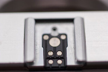 Close up view of a metal component with electrical contacts on a smooth surface in a workshop...