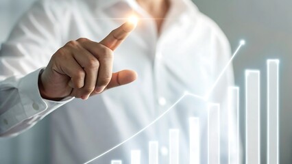 Businessman s finger touching a glowing light on a rising financial graph