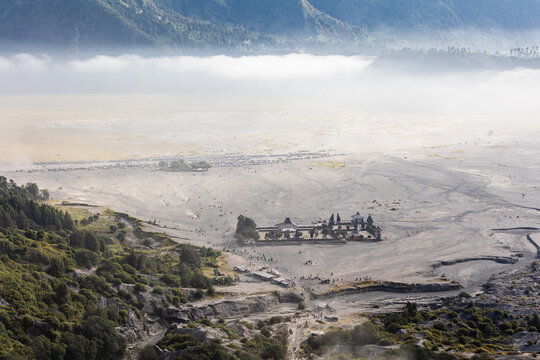 View of the ancient temple nestled on the dusty plains of Mount Bromo, shrouded in ethereal mist, the landscape painted in earthy tones, Mount Bromo Volcano, East Java, Indonesia.