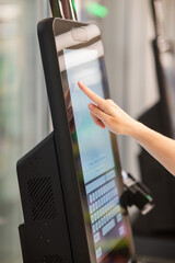 A woman uses a self-checkout machine. 