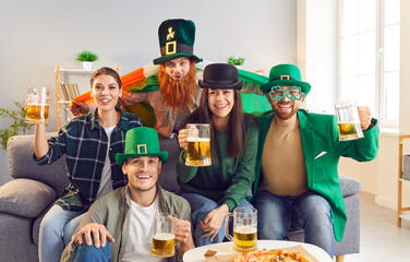 Portrait of a group of happy smiling friends looking cheerful at camera celebrating Saint Patrick's...