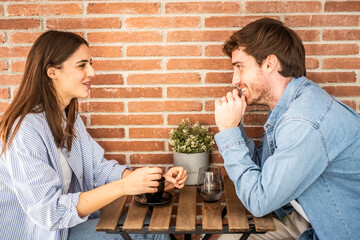 Young couple or friends Eva and Nil chatting happily at table – casual meeting, friendly...