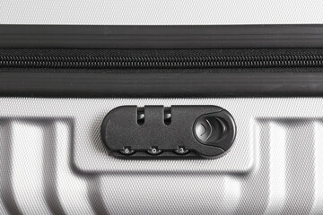 Close-up of numeric lock on silver travel suitcase. Detailed view of zipper with built-in...