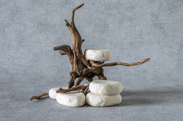 Stone podium, piece of snag on grey background. Minimalist eco backdrop. Pedestal for product advertising. Wabi sabi concept.