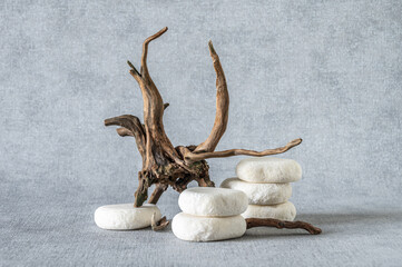 Stone podium, piece of snag on grey background. Minimalist eco backdrop. Pedestal for product advertising. Wabi sabi concept.