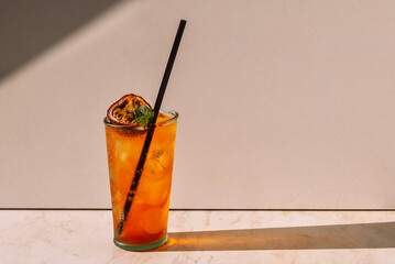 A steamed glass with a tasty carbonated drink and passion fruit. A cool cup of fruit soda with ice...