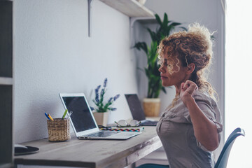 Curly-haired woman in her 40s using a laptop at home with varied expressions. Remote work, digital...